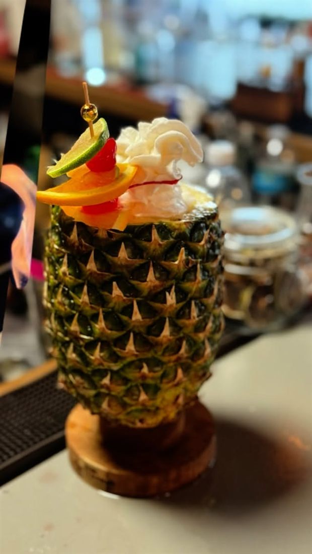 Cóctel servido en piña natural decorado con frutas