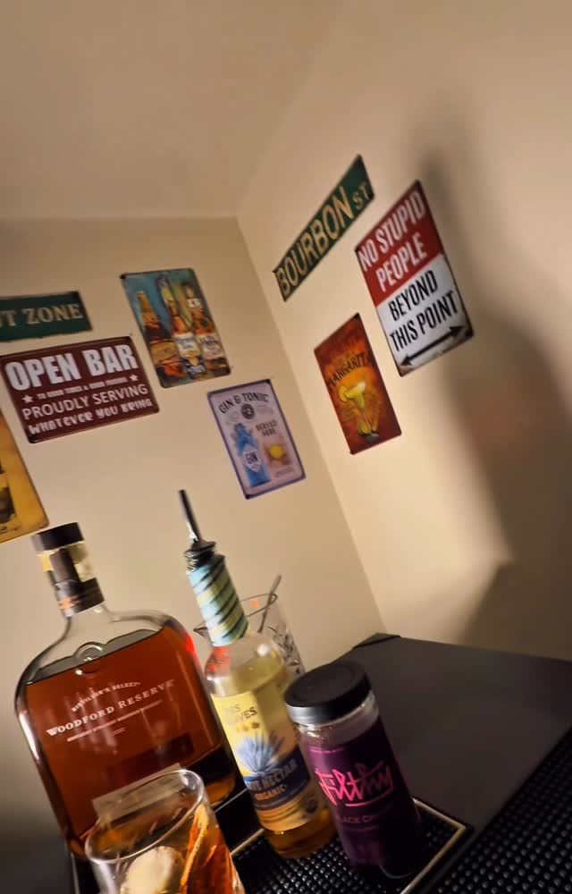 Estación de bar montada en una celebración en casa con whisky y cristalería