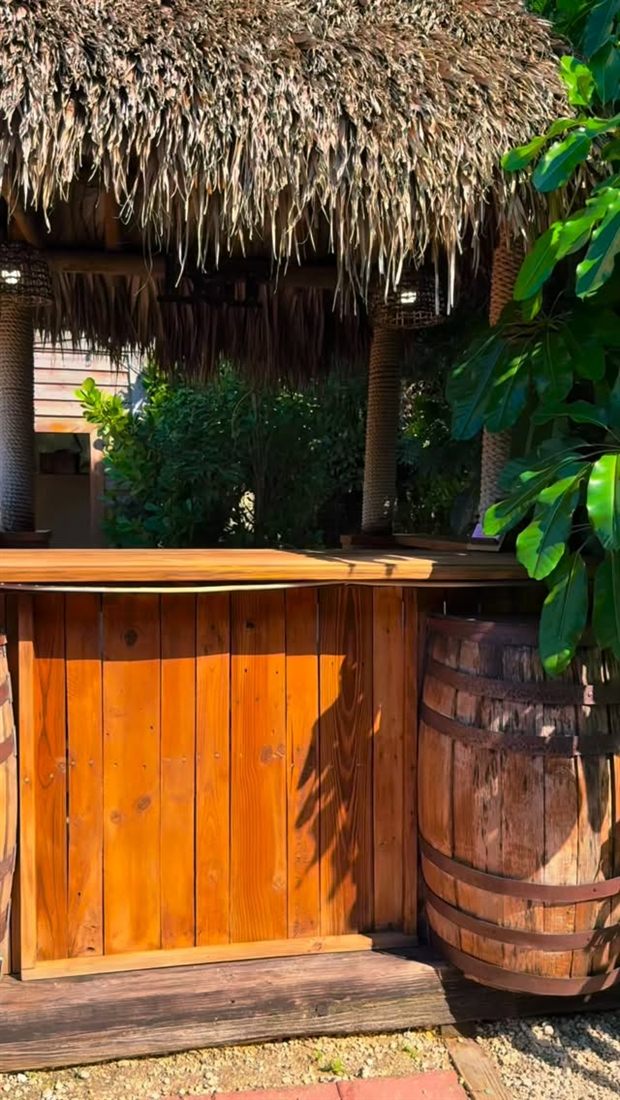 Barra de madera bajo un techo de palma en un evento al aire libre en Miami